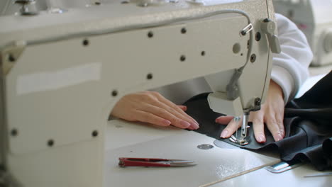 Seamstress-adjusts-the-sewing-machine-to-work.-Young-seamstress-adjusts-the-sewing-machine-to-work.-Hands-close-up